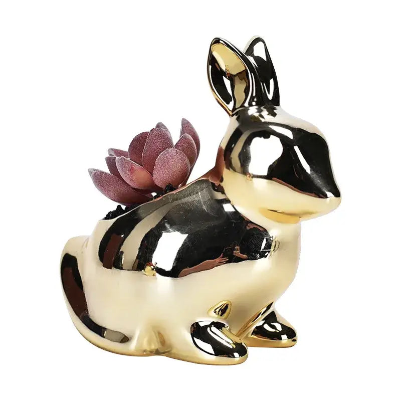 Shiny gold ceramic flower pot shaped as a rabbit with a purple succulent for modern living room decor