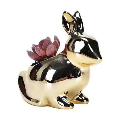 Shiny gold ceramic flower pot shaped as a rabbit with a purple succulent for modern living room decor