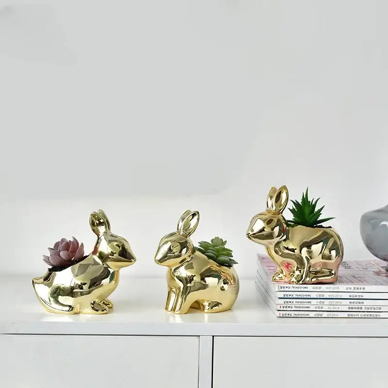 Modern golden ceramic flower pot shaped as a rabbit with glossy finish holding small succulents for living room decor