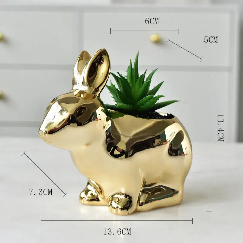 Modern golden ceramic flower pot in the shape of a rabbit with a glossy finish and a green succulent inside