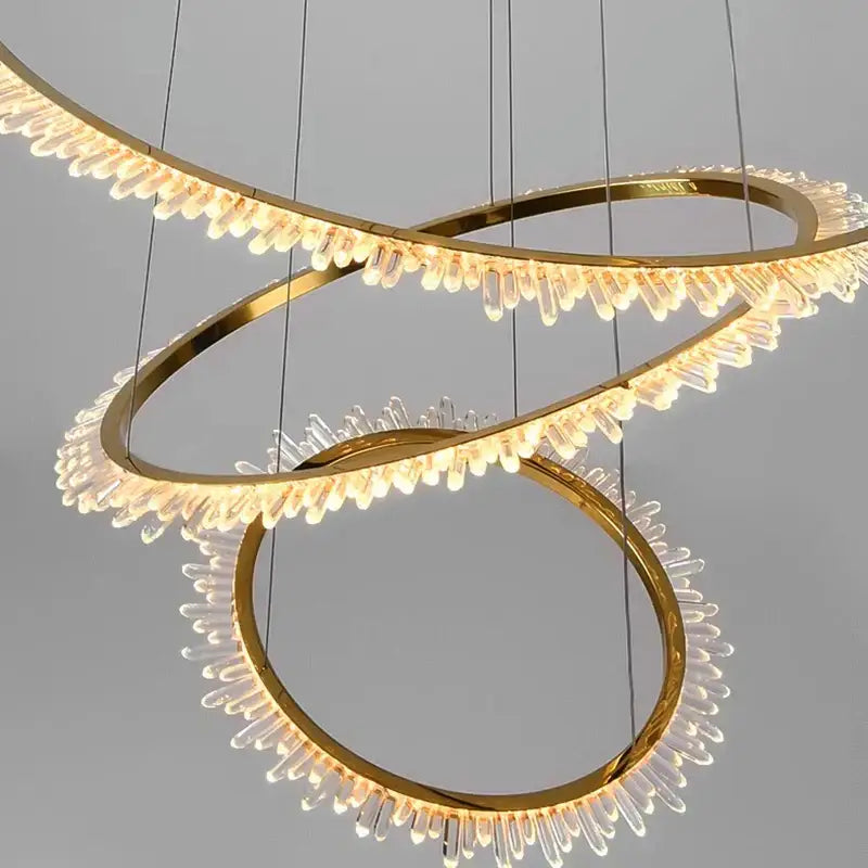 Modern golden spiral decorbites crystal chandelier featuring three interlocking rings with clear crystal droplets