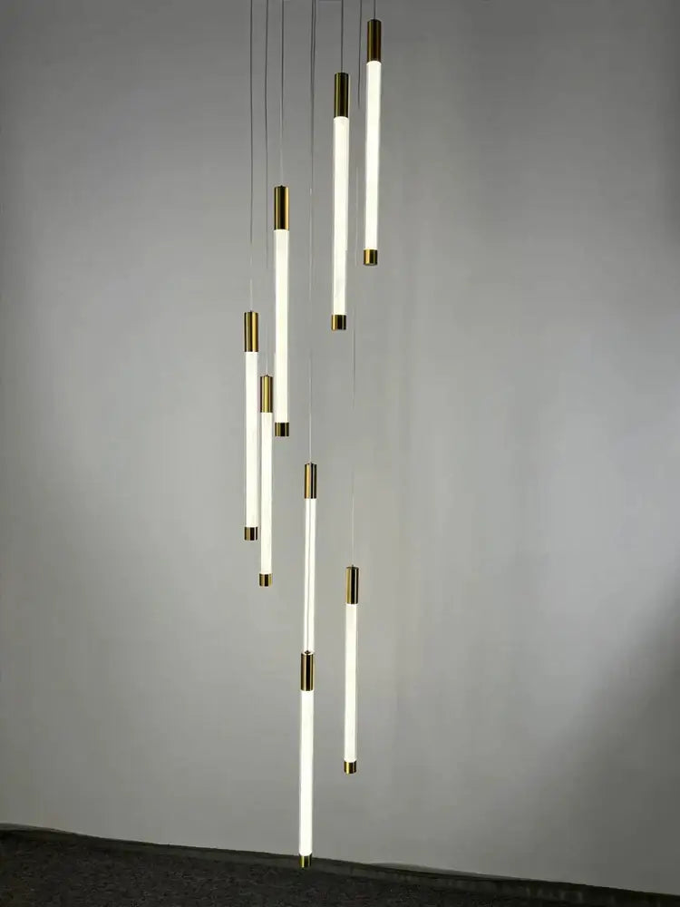 Modern golden tube chandelier with sleek white cylindrical tubes and polished brass accents for staircase decorbites golden tube