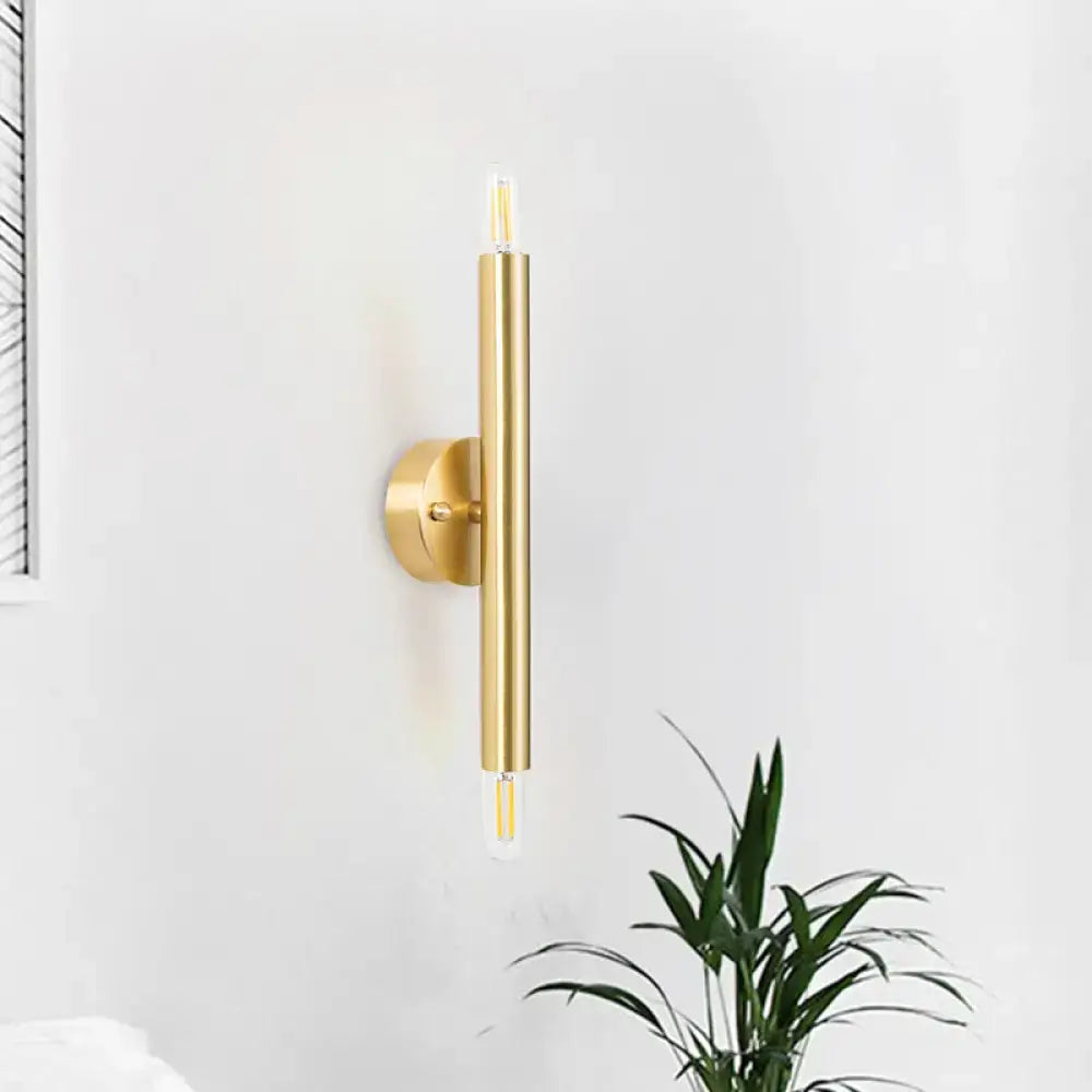 Modern golden tubular wall lamp with sleek cylindrical design and exposed led filament bulbs for bedroom use