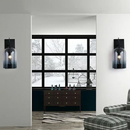 Modern gradient glass sconce lighting fixture with black and blue glass and exposed filament bulbs for wall-mounted lamp use