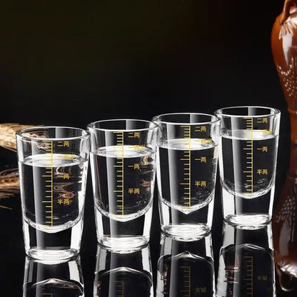 Four clear glass brandy cups with yellow chinese measurement markings in a modern graduated glass spirit set