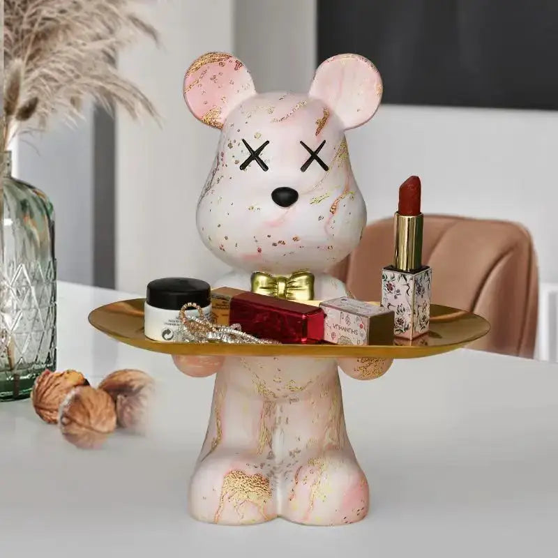 Pink marble-finish bear figurine with gold leaf accents and x’d eyes holding a golden tray for decorbites graffiti bear decor