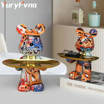 Modern graffiti bear figurine featuring vibrant orange blue and white paint holding golden trays for living room decor