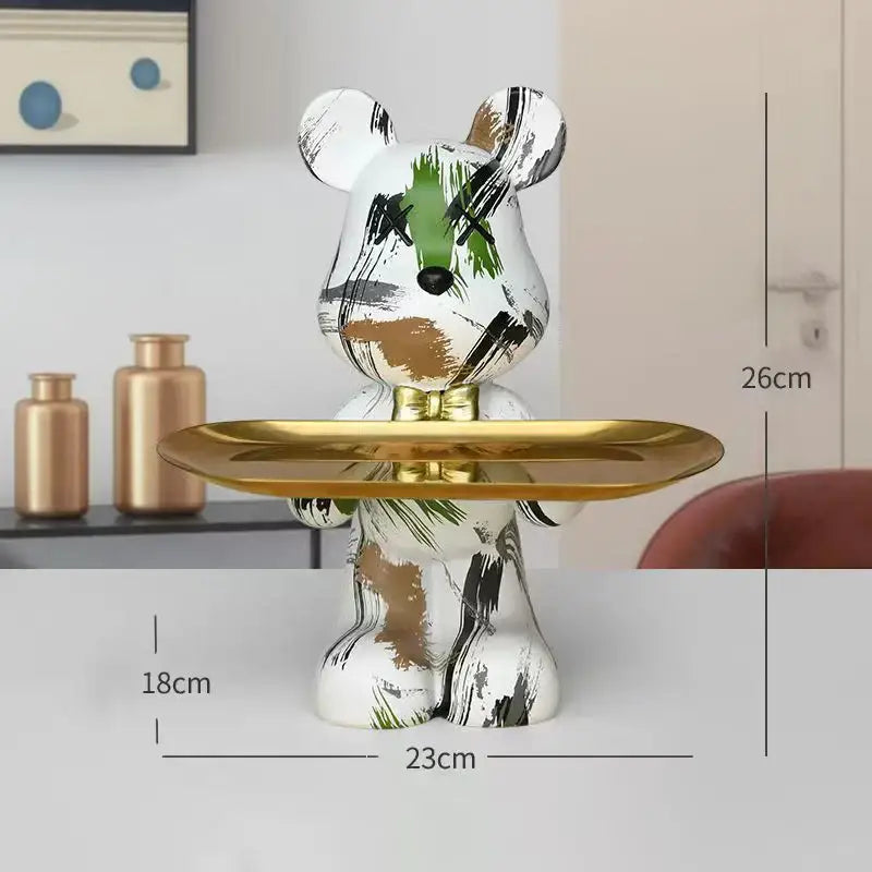 A white ceramic bear figurine with abstract black green and gold brushstrokes holds a shiny golden tray decorbites graffiti bear
