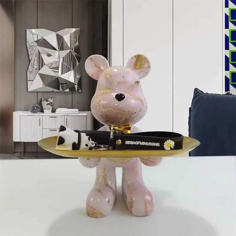 Modern graffiti bear statue ornament in pink marble finish with gold leaf accents holding a black belt with white daisies for home decor