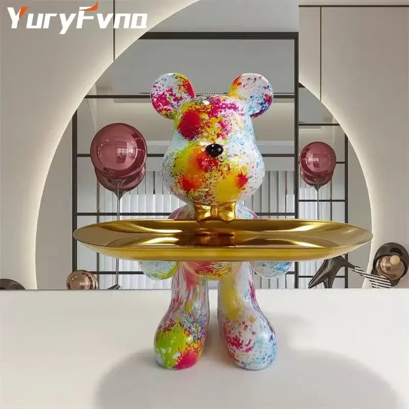 A vibrant splatter-painted bear statue ornament with a glossy finish and gold tray for modern home decor