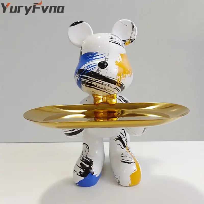 White bear statue ornament with blue black and yellow brushstroke accents holding a gold tray for home decor