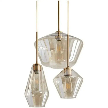 Set of three modern gray amber glass pendant lamps with brass accents and exposed filament bulbs for dining room lighting