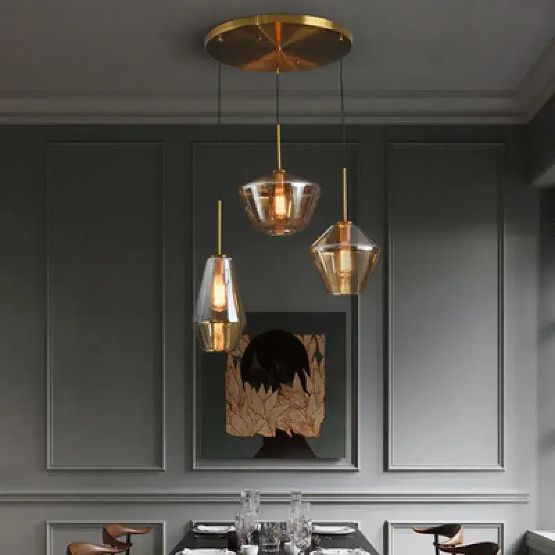 Three modern decorbites gray amber glass pendant lamps with gold-toned fixtures for dining room lighting