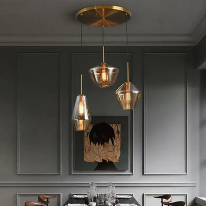 Three modern decorbites gray amber glass pendant lamps with gold-toned fixtures for dining room lighting