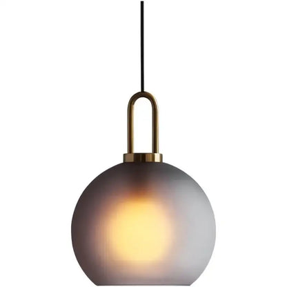 Modern gray and brass glass pendant light fixture with frosted spherical shade for kitchen lighting