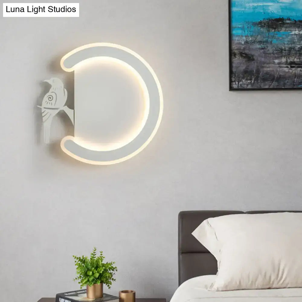 Modern gray crescent-shaped wall lamp with white bird silhouette emitting warm white light for bedroom ambiance