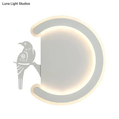 Modern gray wall lamp with crescent shape and bird silhouette providing warm white light for bedroom ambiance