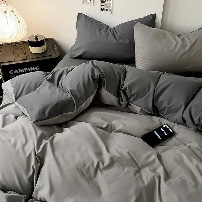 Modern gray comforter cover set with geometric throw and plush quilted texture featuring matching pillows