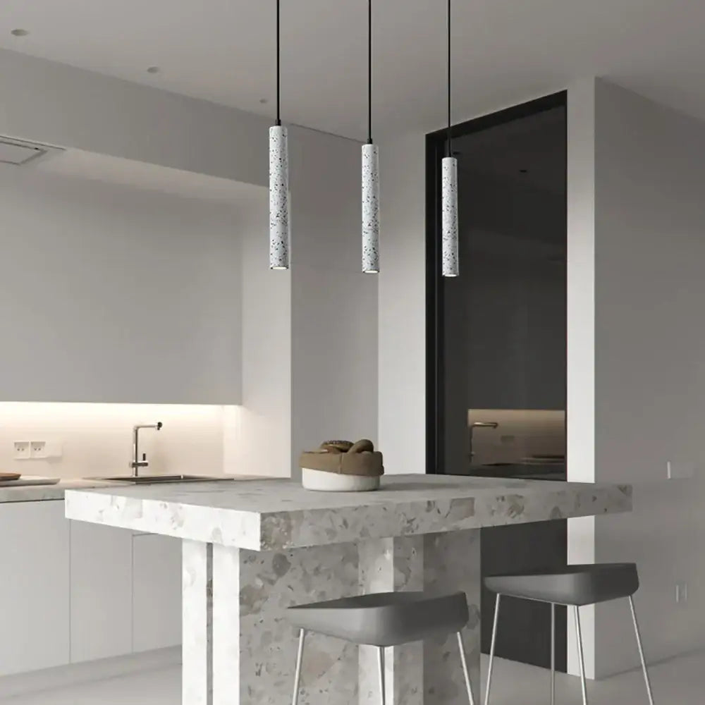 Modern gray concrete tube pendant light dining room triple chandelier with speckled finish hanging above kitchen island