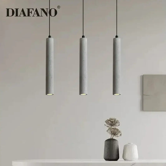 Modern gray concrete tube pendant light with three sleek cylindrical shades hanging from black cords for dining room decorbites concrete tube pendant