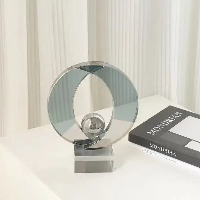 Modern gray geometric crystal glass decorbites ornament with chrome abstract rings and central sphere on acrylic base