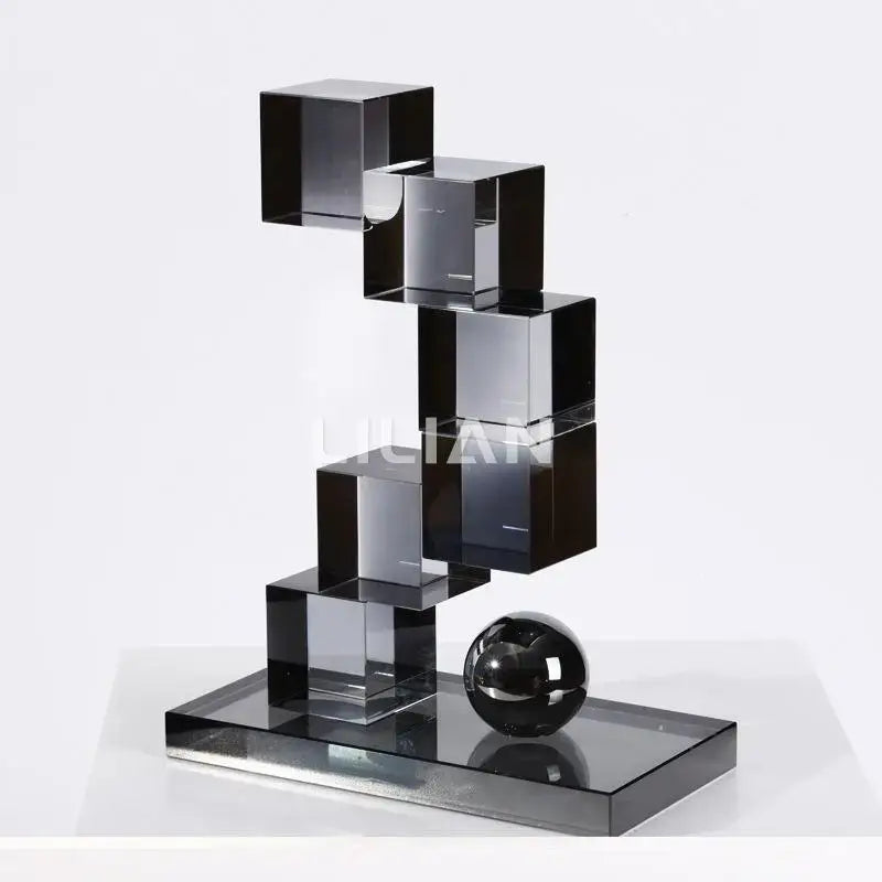 A sleek modern gray geometric crystal glass sculpture with stacked black cubes and a polished sphere for living room decor