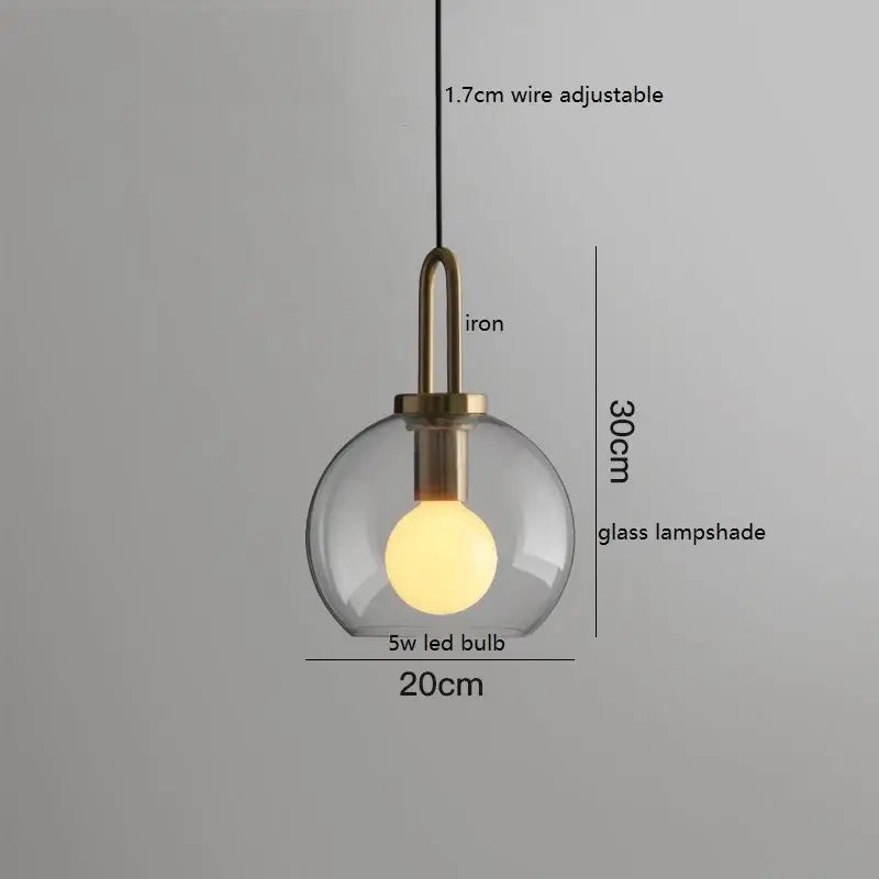 Modern gray glass ball led pendant light featuring a clear glass shade iron fixture with brass accents by decorbites
