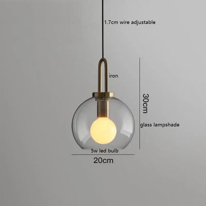 Modern gray glass ball led pendant light featuring a clear glass shade iron fixture with brass accents by decorbites