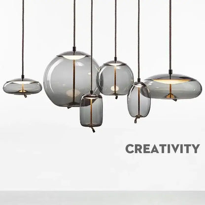 Set of modern gray glass chandelier knot pendant lamps with translucent shades and black cords for dining room lighting