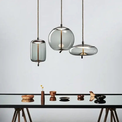 Modern gray glass knot pendant chandelier light with translucent shades and brass cords for dining room lighting