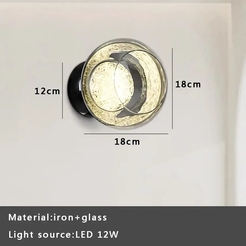 Circular gray glass wall lights with textured frosted finish and black iron base for modern living room sconce