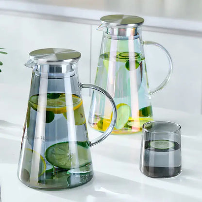 Modern gray glass water pitcher with stainless lid filled with water and sliced lemons and limes for kitchen use