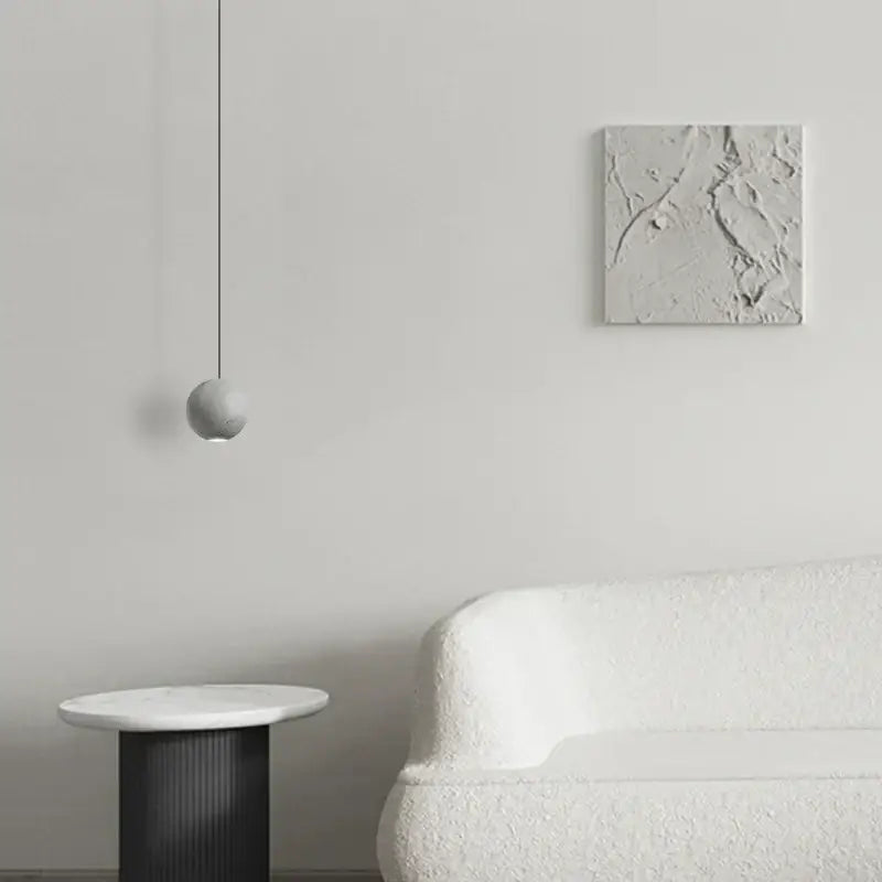 Modern gray and gold cement chandelier with a minimalist gray spherical pendant light on a black cord for dining room decorbites cement chandelier