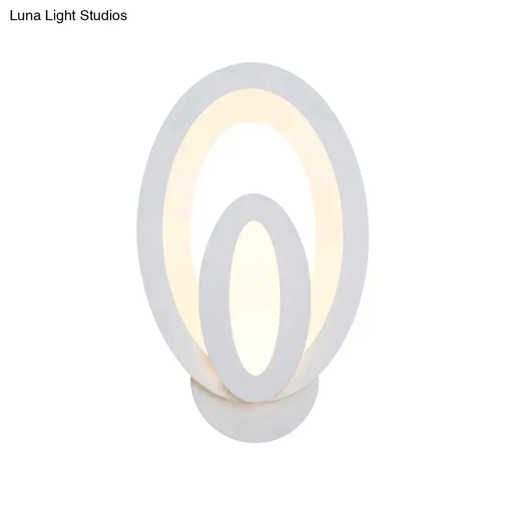 Modern white oval wall sconce with concentric rings emits warm white light and supports direct wired electric maximum bulb wattage