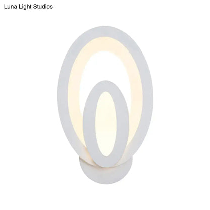 Modern white oval wall sconce with concentric rings emits warm white light and supports direct wired electric maximum bulb wattage
