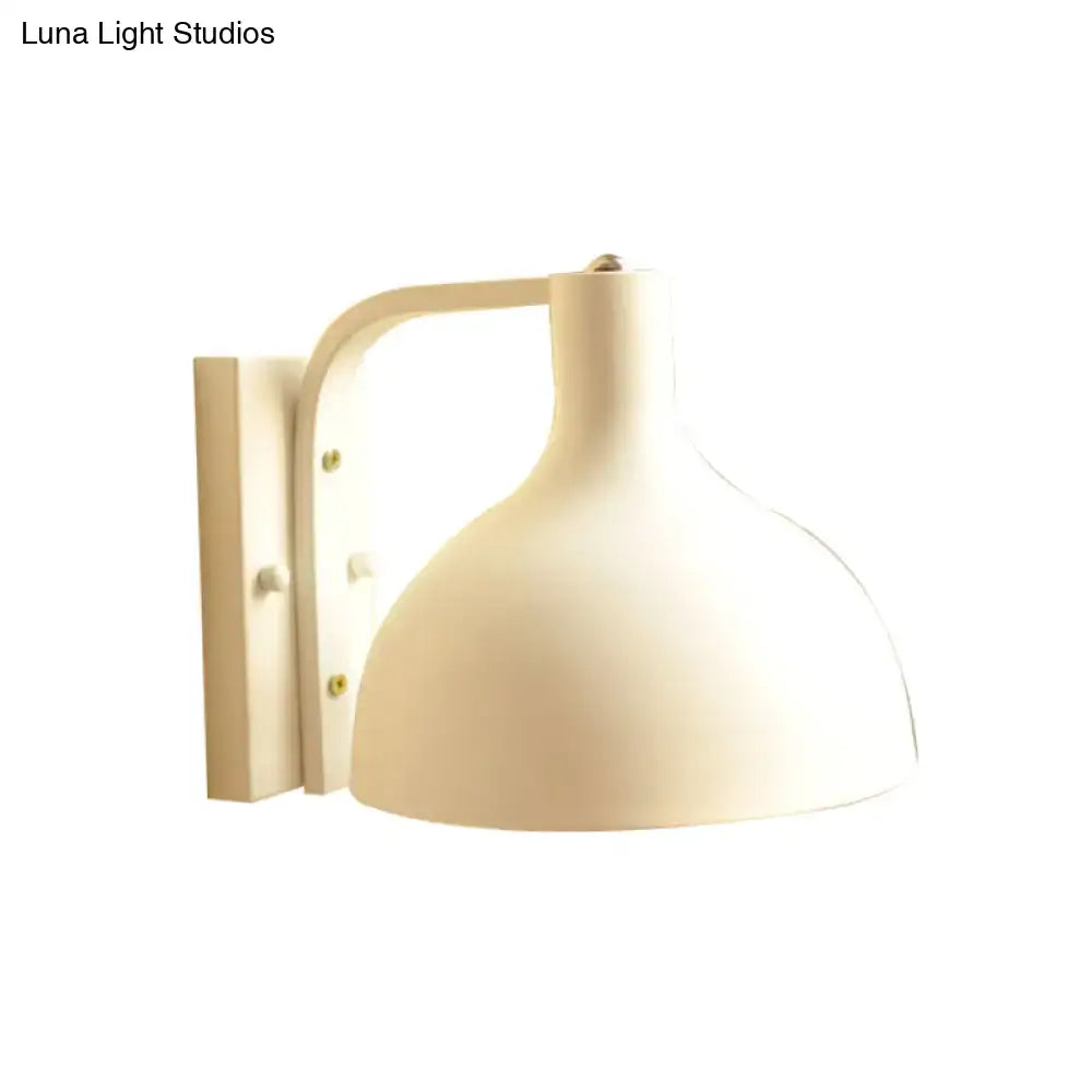 Modern gray metal domed wall sconce with cream-colored dome-shaped shade and curved arm for hallway lighting
