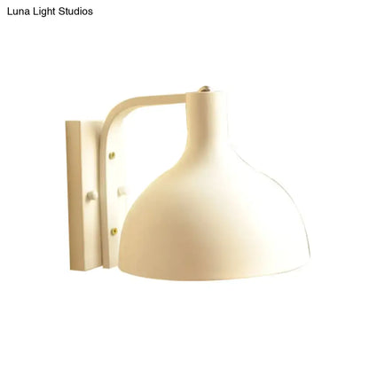 Modern gray metal domed wall sconce with cream-colored dome-shaped shade and curved arm for hallway lighting