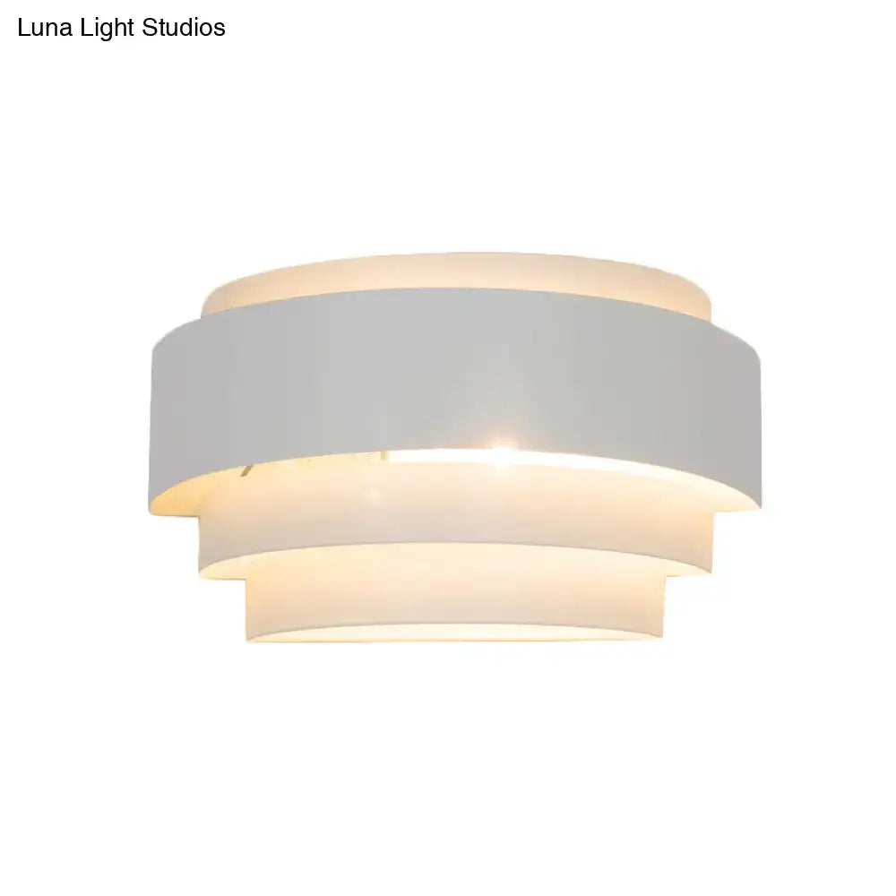 Modern gray metal wall sconce with etched pattern and tiered matte white glass shades for living room warm glow light