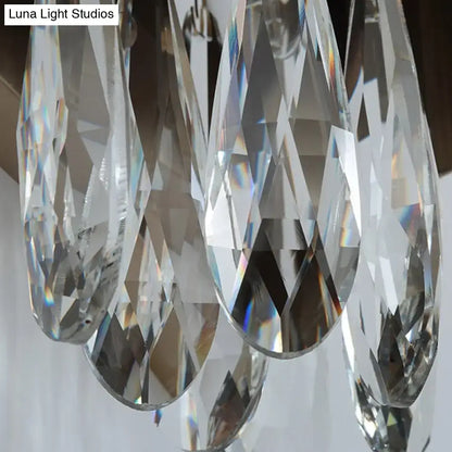 Clear faceted crystal teardrop pendants hanging from a modern gray metallic crystal teardrop wall sconce bedroom light