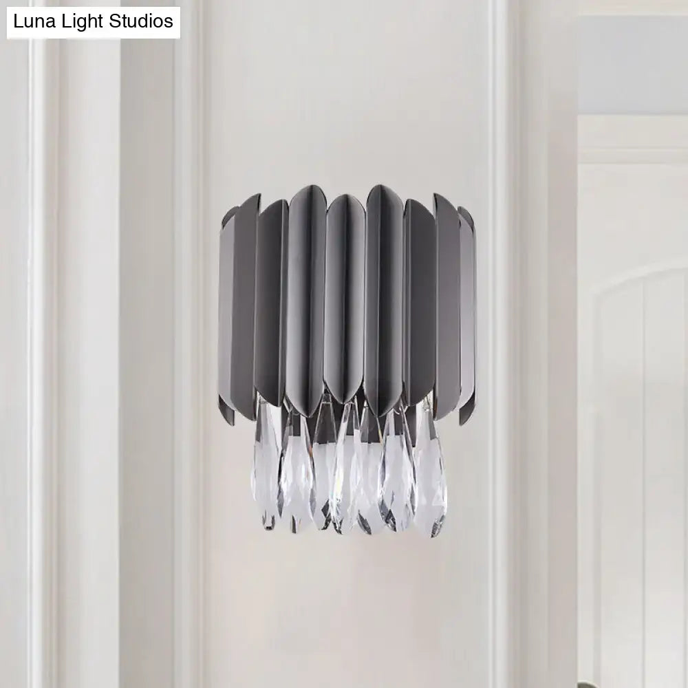 Modern gray metallic wall sconce with sleek blades and dangling clear crystal teardrop accents for bedroom lighting