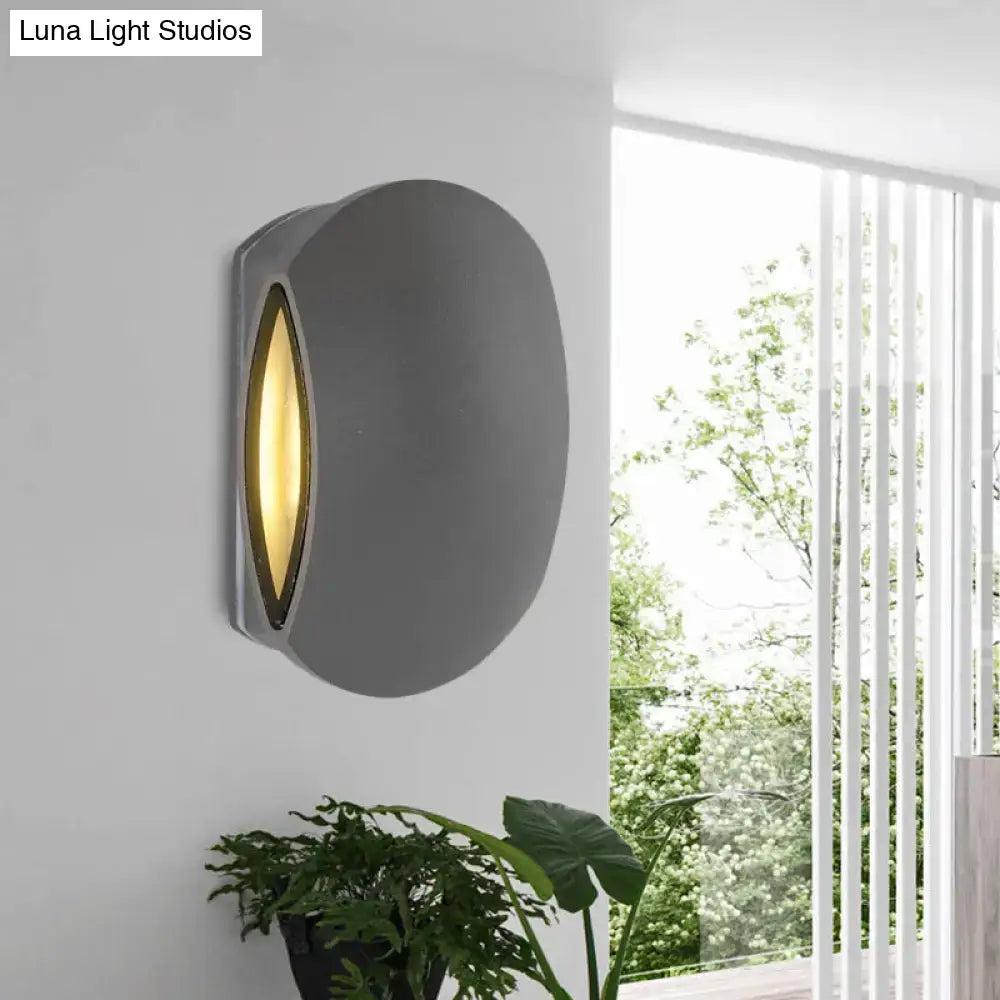 Modern gray oval wall light with warm white bulb included emitting warm yellow light for outdoor use