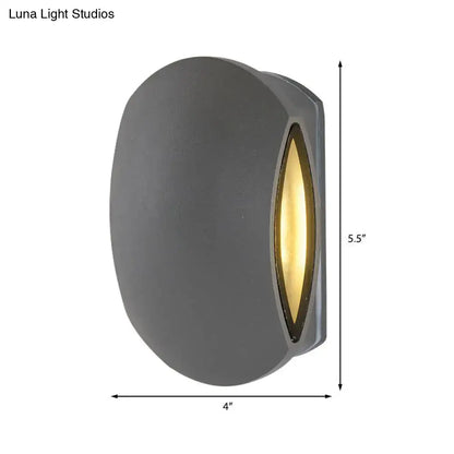 Modern gray oval wall light outdoor sconce with warm white bulb included emitting yellow light from vertical lens