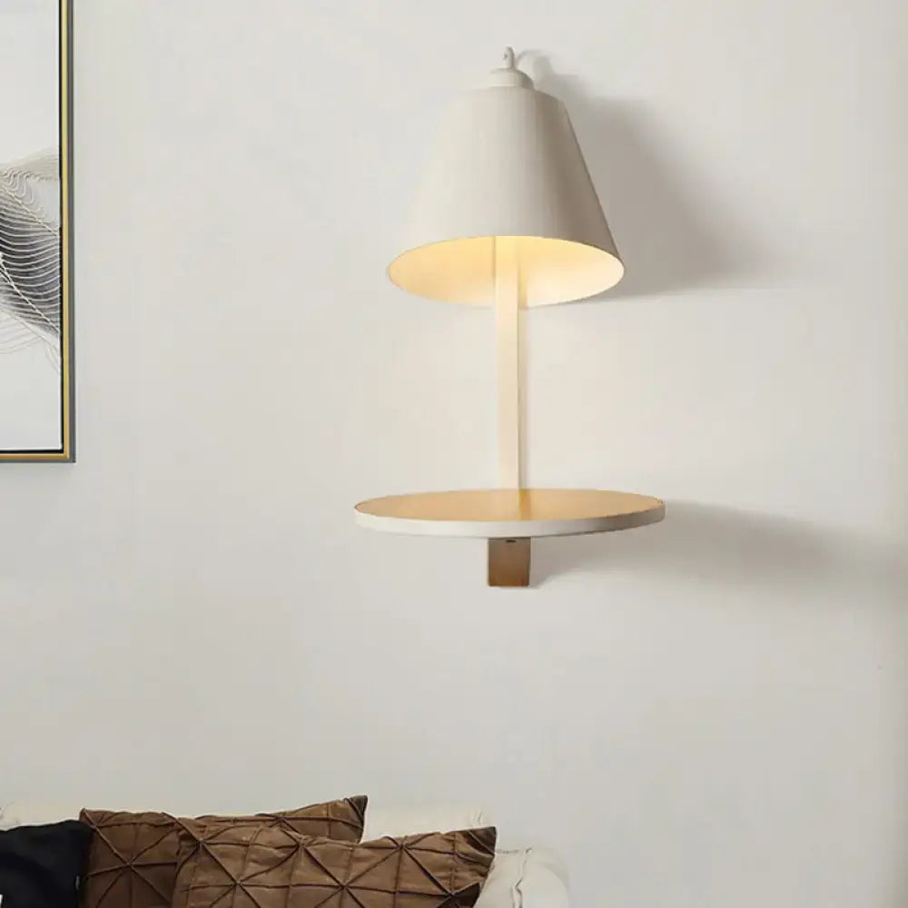 Modern white gray tapered wall sconce with conical shade and wooden shelf providing warm bedroom ambient lighting