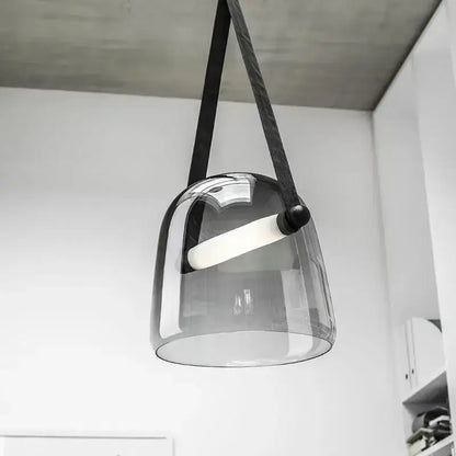 A modern gray and white decorbites glass chandelier with a sleek translucent glass pendant and black fabric strap