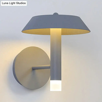 Modern gray and white wall sconce with matte finish, cylindrical stem, warm yellow interior, and LED light type bulb base