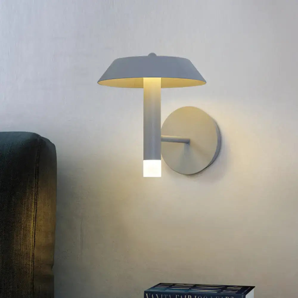 Modern gray and white wall sconce with a bulb base emitting warm yellow light for bedroom LED light type use
