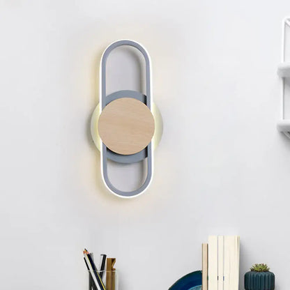 Modern gray and wood geometric led sconce with white light featuring a minimalist circular design for bedroom lighting