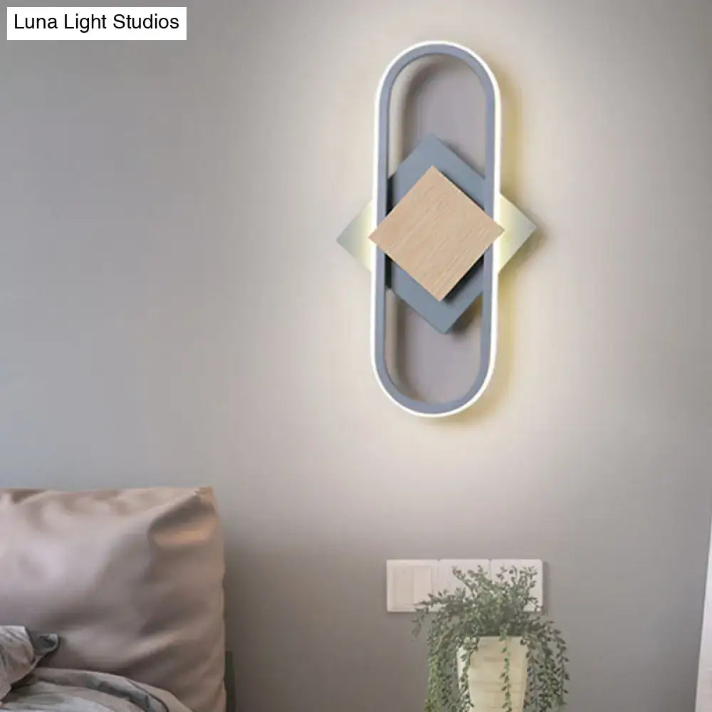 Modern gray and wood geometric led sconce with layered diamond panels emitting white light for bedroom lighting