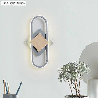 Modern gray and wood geometric led sconce with layered diamond panels emitting white light for bedroom use