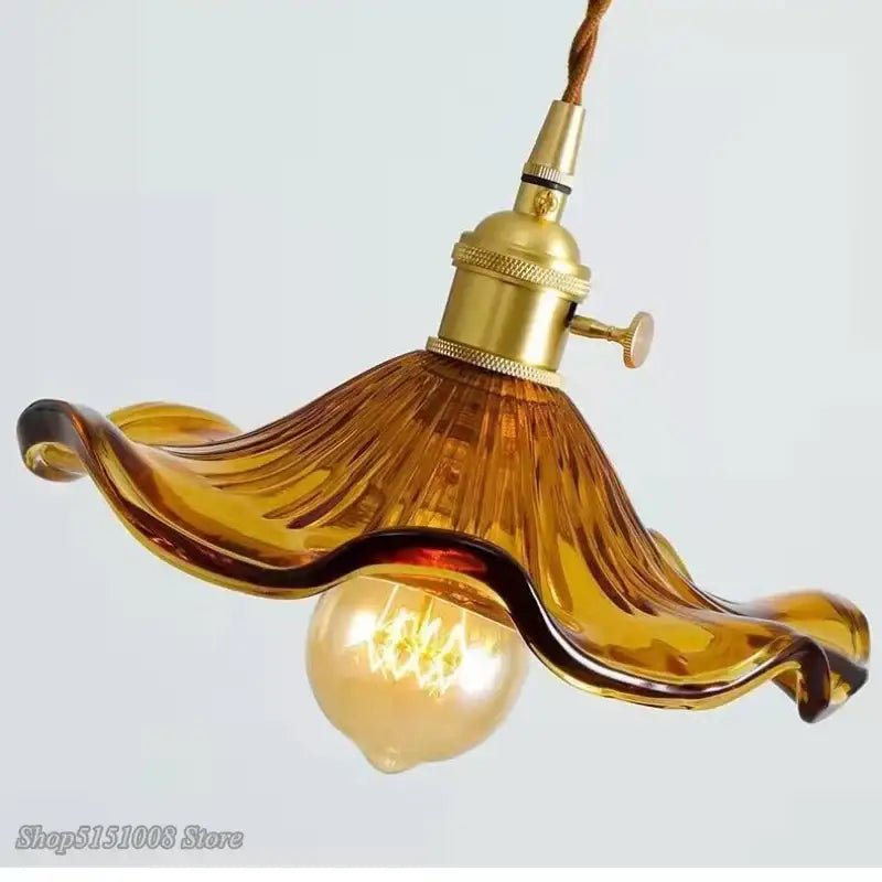 Amber-colored hand-blown glass pendant light with brass-finished socket and twisted cord for colorful glass cord pendant installation